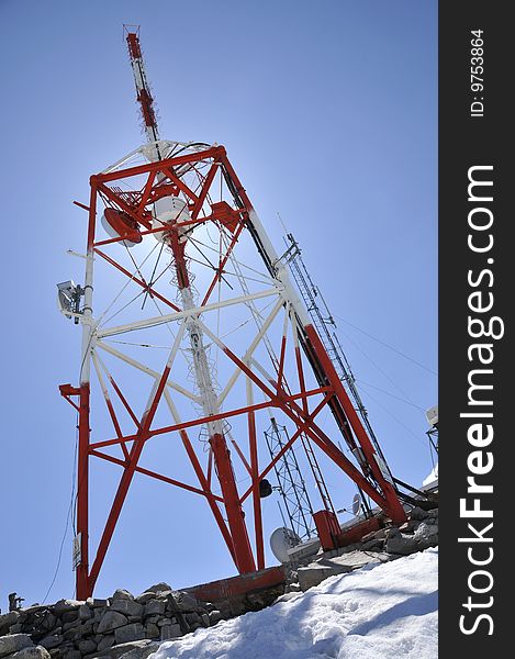 Weather and Telecommunication Station on Top of Mountain Peak with Clouds and Towers in Background. Weather and Telecommunication Station on Top of Mountain Peak with Clouds and Towers in Background