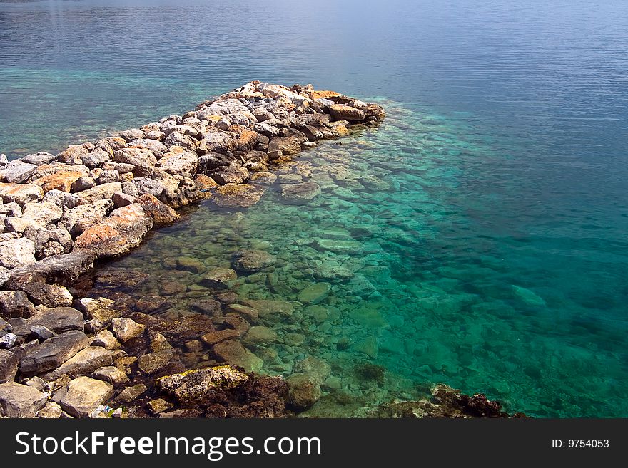 Stone pier and transparent sea water
