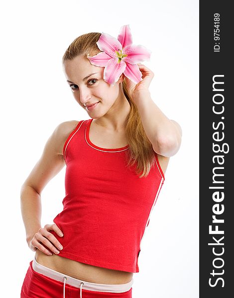 A nice blond girl in red posing with a pink lily near her face on a white background. A nice blond girl in red posing with a pink lily near her face on a white background