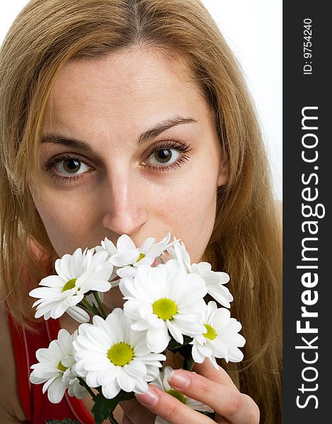 A smiling beautiful blonde in red with a bouquet of white chrysanthemums in her hands. A smiling beautiful blonde in red with a bouquet of white chrysanthemums in her hands