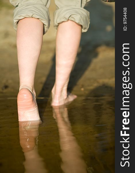 Girl's barefoot legs in the river. Girl's barefoot legs in the river