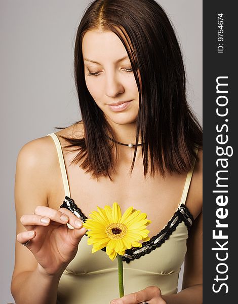 An image of a woman with a yellow flower. An image of a woman with a yellow flower
