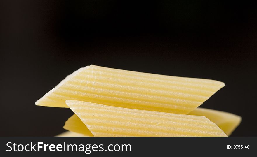 Close up of penne on a black background. Close up of penne on a black background