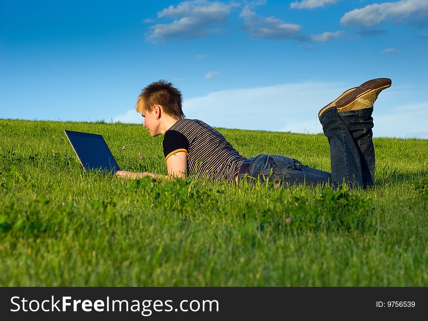 Young girl on a green grass with laptop. Young girl on a green grass with laptop