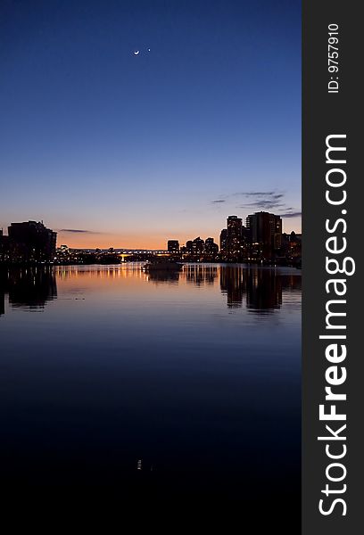 Shortly after sunset, venus and moon are visible over Vancouver city and reflecting in the quite bay. Shortly after sunset, venus and moon are visible over Vancouver city and reflecting in the quite bay
