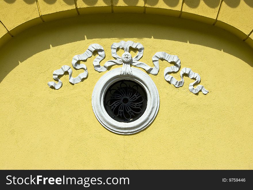 Small window in wall with white ornament