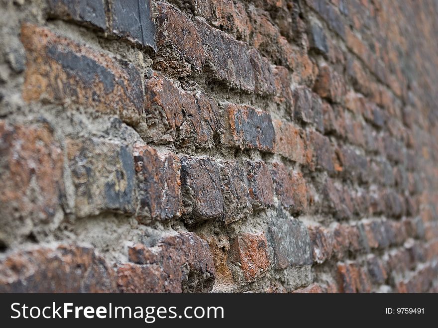 Lot of bricks in one ruined red wall