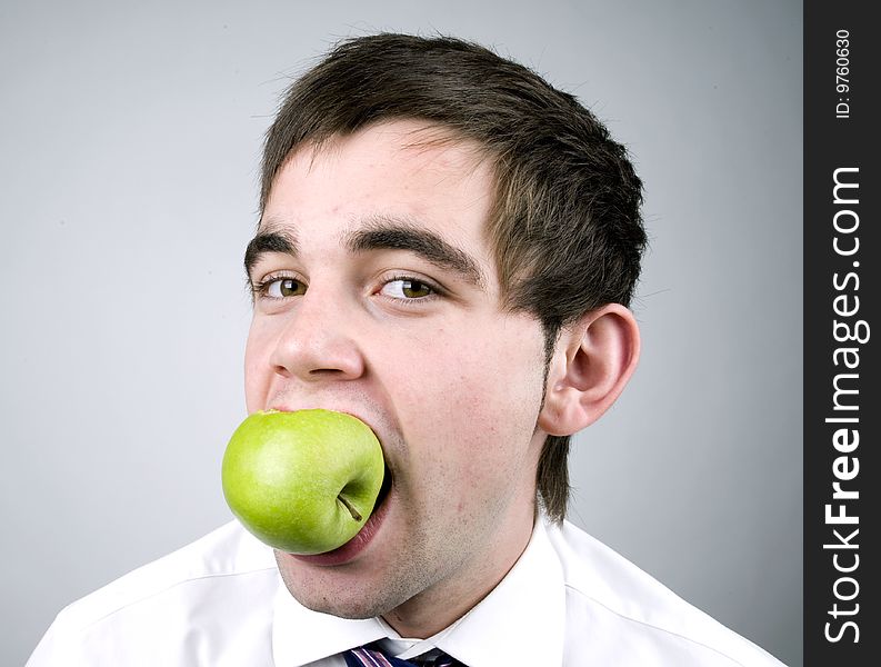 Young man eats a fresh green apple. Young man eats a fresh green apple