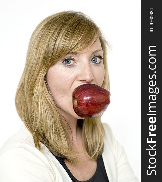 Pretty Blonde girl holds red apple in mouth. Pretty Blonde girl holds red apple in mouth