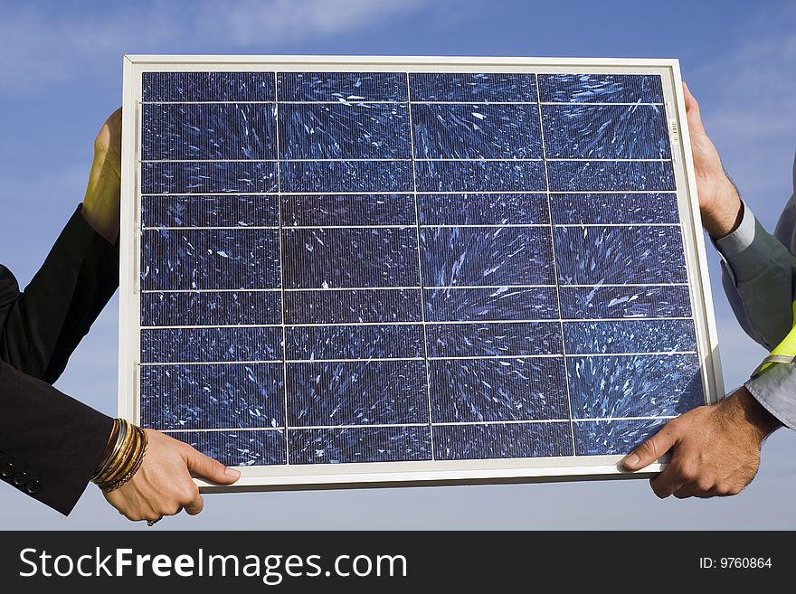 Hands holding a solar panel