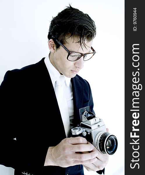 Stylish gentleman holds vintage camera while wearing suit. Stylish gentleman holds vintage camera while wearing suit