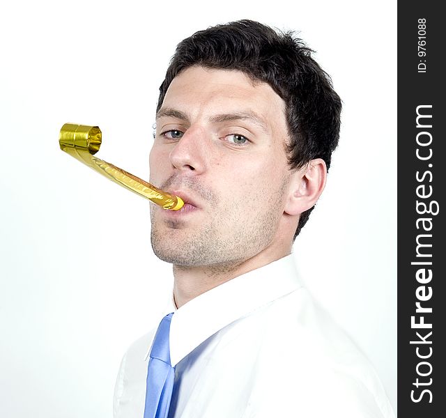 Business man blows party blower while wearing whit shirt. Business man blows party blower while wearing whit shirt.