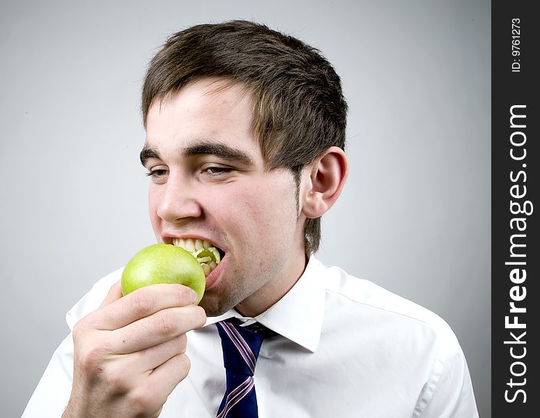 Young man eats a fresh green apple. Young man eats a fresh green apple