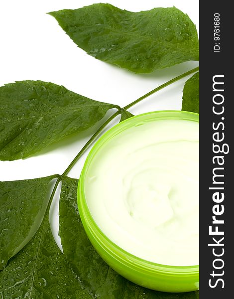 Face cream with green leaf on white background