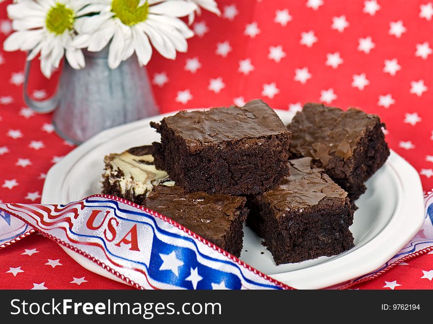 Fudge brownies with holiday ribbon and daisies on a star background. Fudge brownies with holiday ribbon and daisies on a star background.