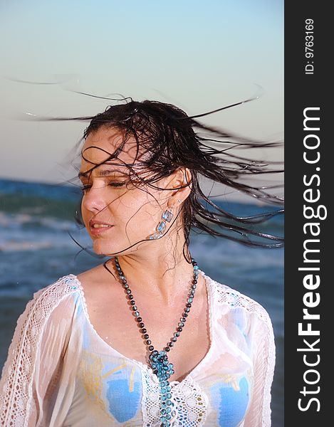Portrait of young woman waving wet hair on the beach
