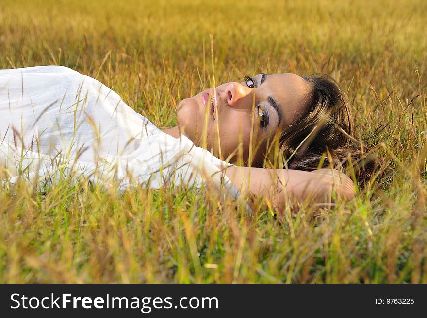 Portrait of young female beauty lying on the grass. Portrait of young female beauty lying on the grass