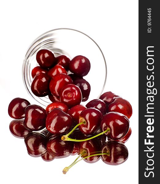 Cherry rolling out from a dish with white background