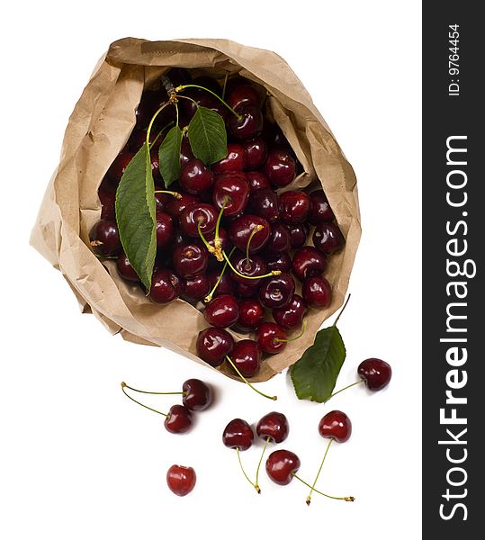 Fresh red cherry rolling out from a paper bag with white background