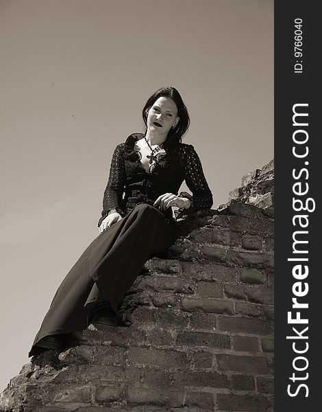 Young gothic girl and ruins of castle