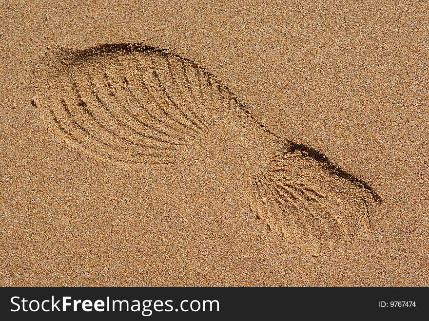 Imprint of a shoe tread pattern on a sandy beach. Imprint of a shoe tread pattern on a sandy beach.