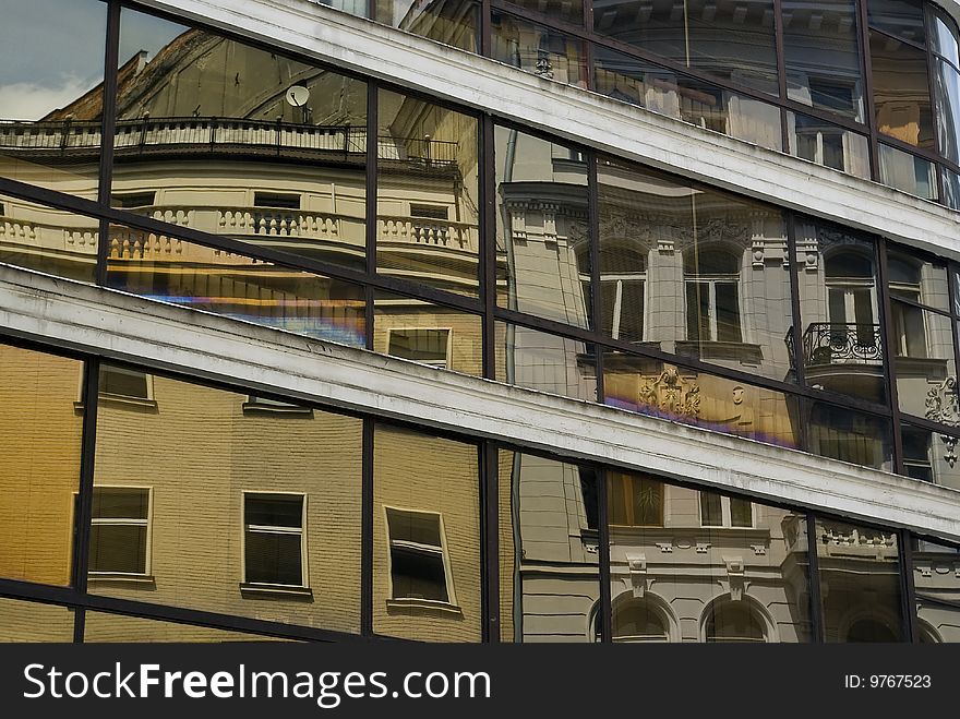 Mirrored buildings in glass window of other house