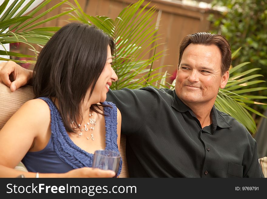 Attractive Hispanic and Caucasian Couple Drinking Wine Outside.