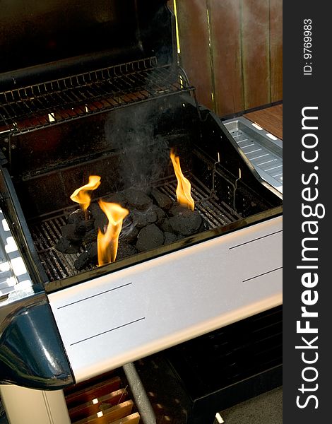 Chrome and blue Barbecue fire with orange flames and black charcoal