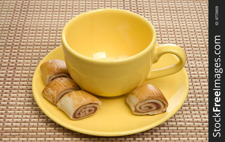 Yellow tea cup and cookies with jam