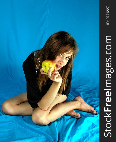 Girl sits and holds apple, he tempts. Girl sits and holds apple, he tempts