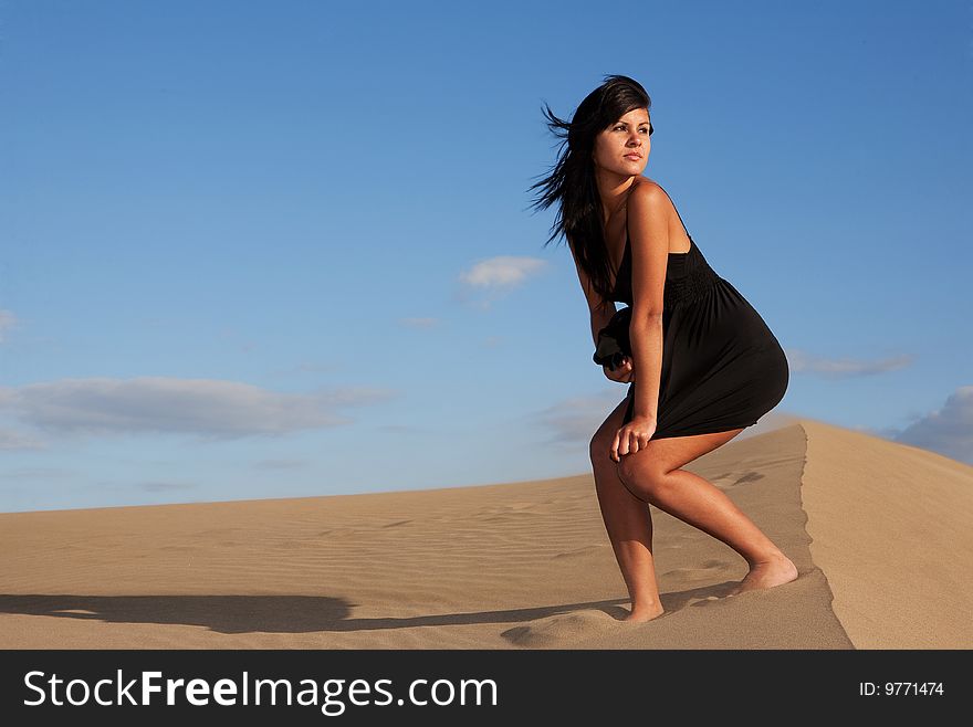 Young beautiful woman on sand in a windy day. Young beautiful woman on sand in a windy day
