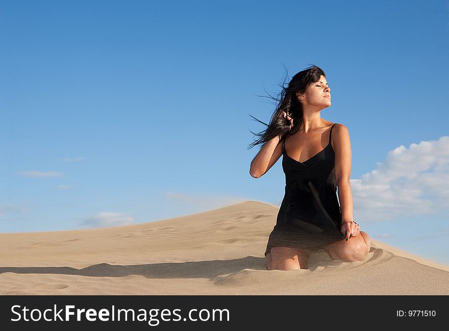 Young beautiful woman on sand in a windy day. Young beautiful woman on sand in a windy day