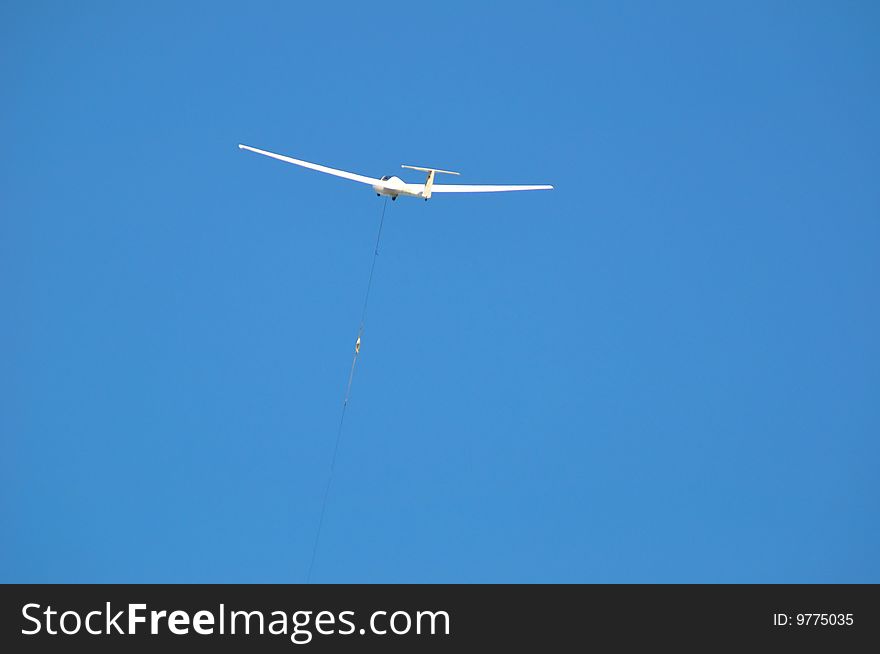 A sailplane against blue sky with white summer clouds