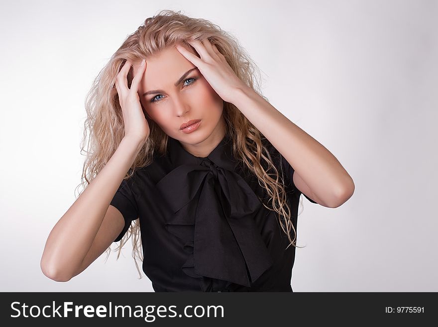 Young businesswoman in black blouse having a headache, studio shot