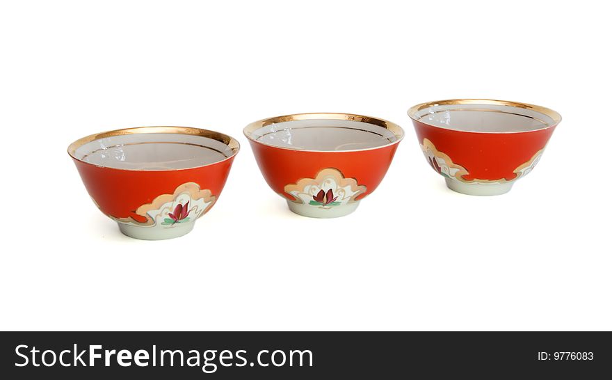 Three small asian porcelain red drinking bowls with floral pattern isolated. Three small asian porcelain red drinking bowls with floral pattern isolated