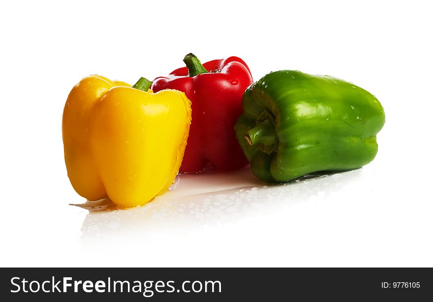 Three fresh peppers under pouring water isolated over a white background