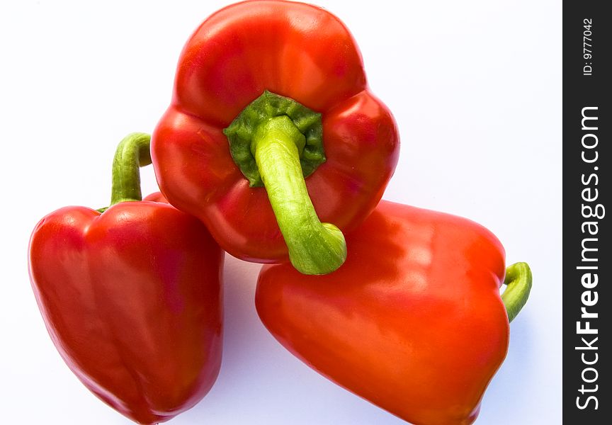 Overhead shot of three red bell peppers on white background. Overhead shot of three red bell peppers on white background
