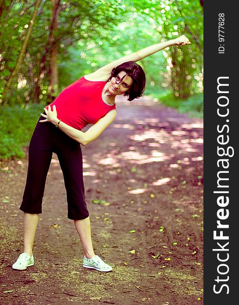 Sporty woman working out on a forest path.
