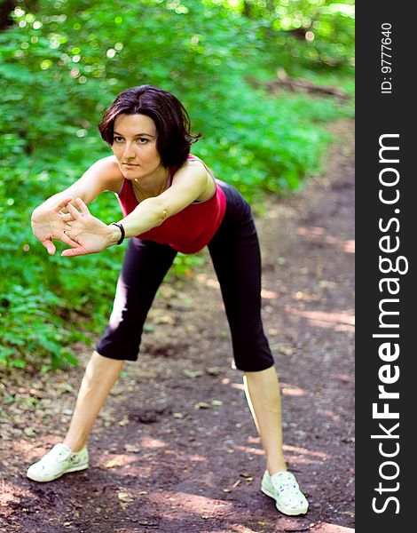 Sporty woman working out on a forest path.