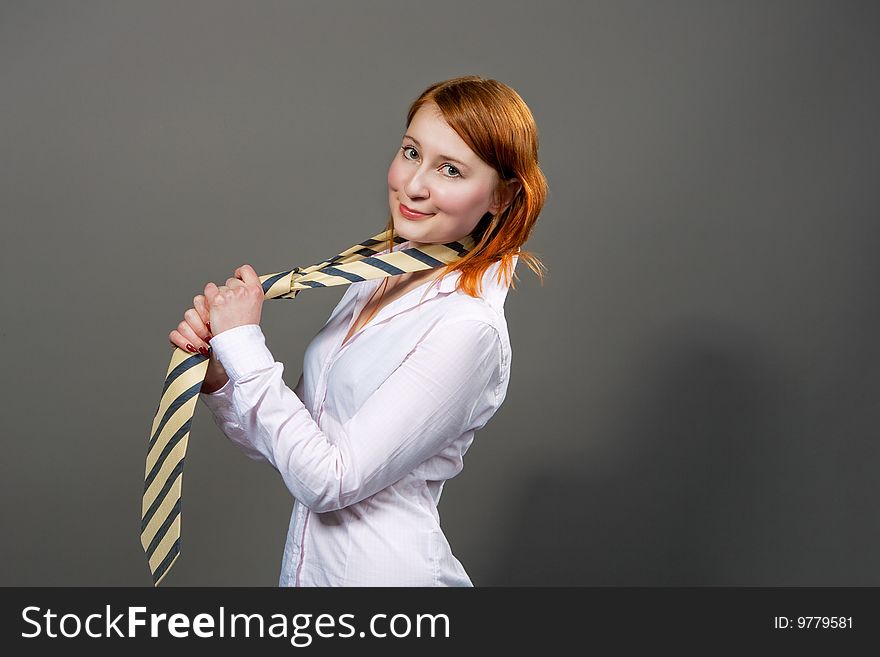 Red haired girl smiling with tie isolated. Red haired girl smiling with tie isolated