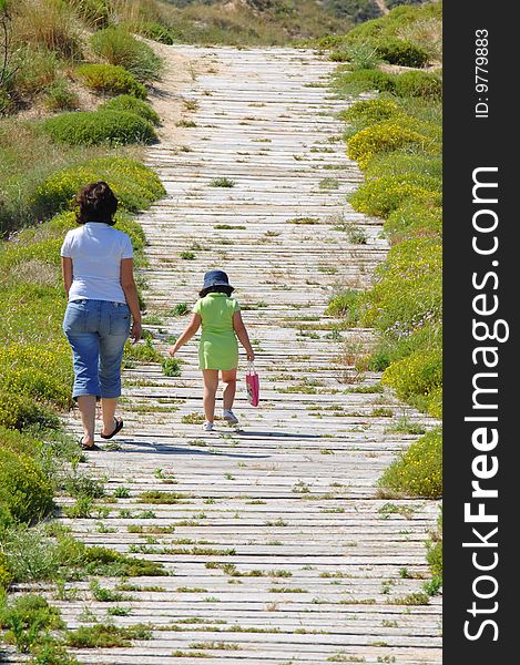 Mother and is daughter walking near the beach