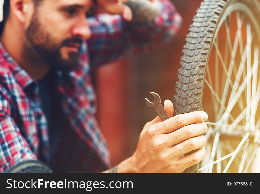 Man repairing bike with wrench