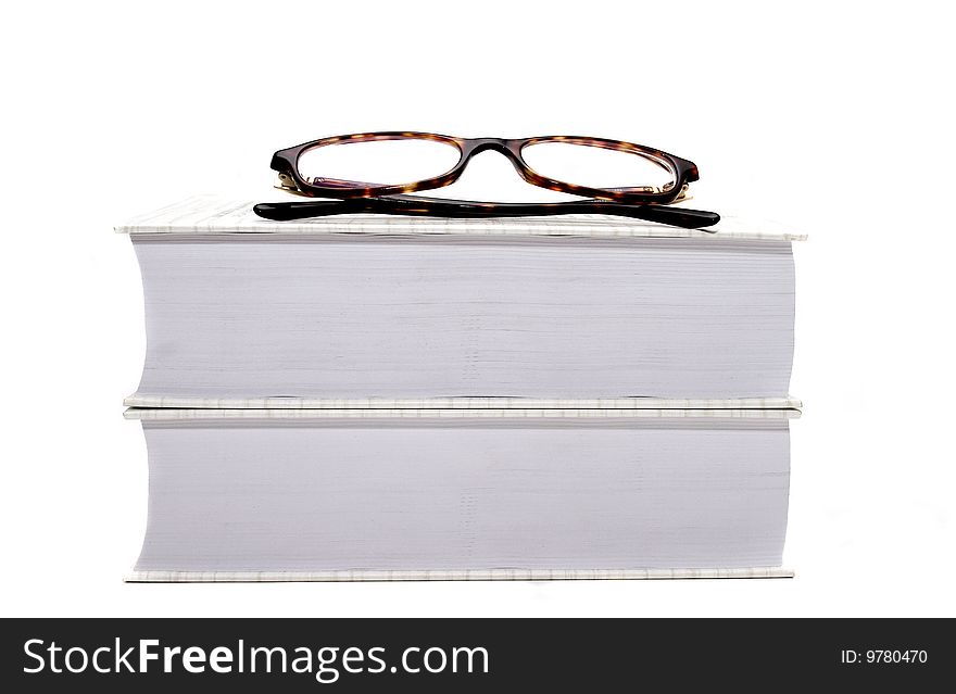 Couple of books with glasses on top over white. Couple of books with glasses on top over white