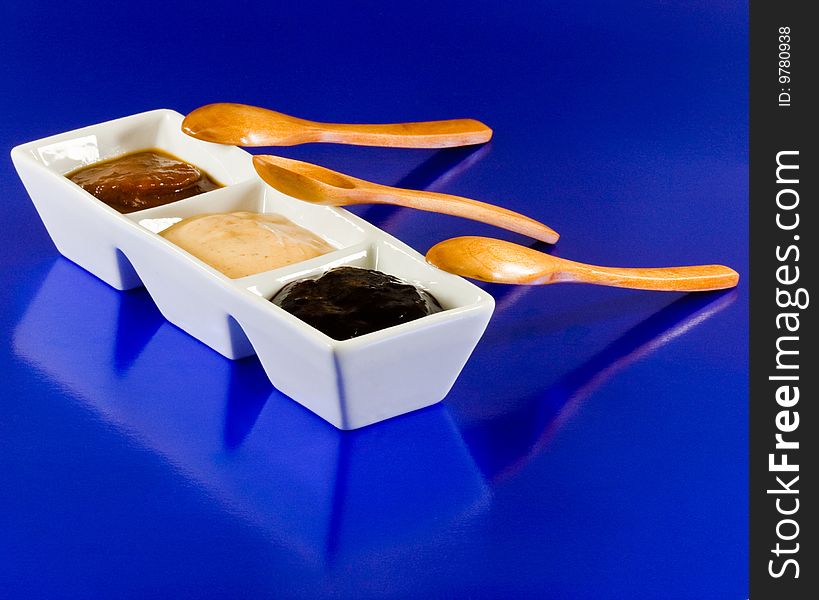 Sauces In Container With Spoons On Blue Background