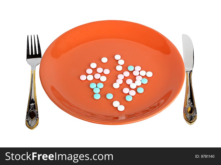 Dinner plate with pills. Fork and knife. Isolated