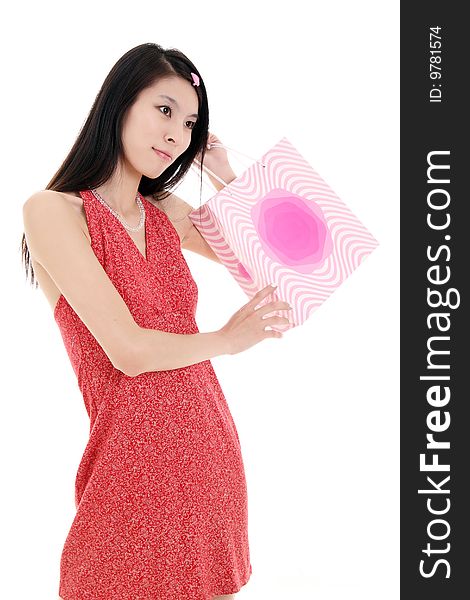 A beautiful Asian girl holds a shopping bag on white background. A beautiful Asian girl holds a shopping bag on white background.