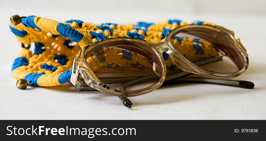 Eyeglasses with a yellow and blue woven case.  Isolated on white background. Eyeglasses with a yellow and blue woven case.  Isolated on white background.