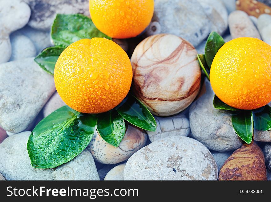 Three mandarin with drops between the sea stones. Three mandarin with drops between the sea stones