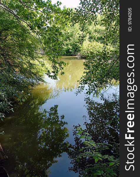 Scenic river landscape in tree branch green frame