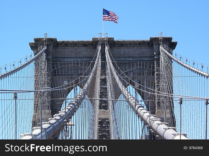 American flag waving over the Brooklyn Bridge